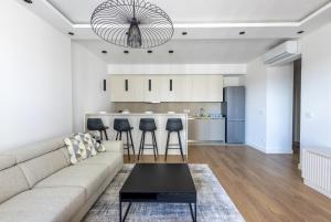a living room with a couch and a kitchen at Terra Luxe Residences in Sajmište