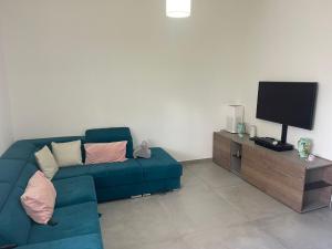 a living room with a blue couch and a television at Etna sotto il ciliegio in Ragalna