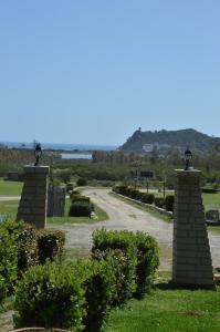 a walkway through a garden with bushes and trees at Il Falconiere in Muravera