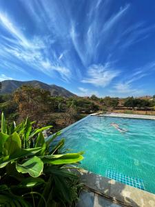 a swimming pool with a view of the mountains at The Riverside Estate - 2Bedroom Private Pool Villa in Udaipur in Udaipur