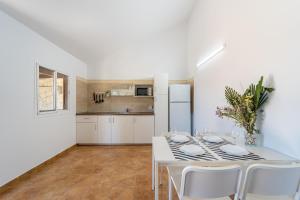 een witte keuken met een witte tafel en stoelen bij Apartamento Jibazahora Leo in Zahora