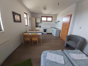 a living room with a table and a kitchen at Pivní lednice in Lhota pod Libčany