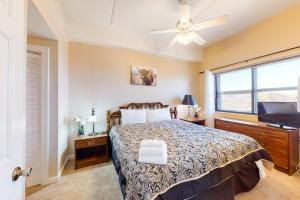 a bedroom with a bed with a ceiling fan and a window at Sugar Top Condos II in Sugar Mountain