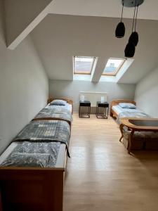 クラクフにあるSunnyvale Apartmentのベッド3台、テーブル、窓が備わる客室です。