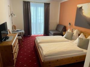 a hotel room with a bed and a desk and a chair at Hotel Solaria in Obertauern