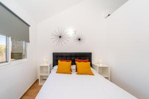 um quarto branco com uma cama com almofadas amarelas em Apartamento Jibazahora Libra em Zahora