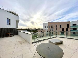 d'un balcon avec une table et une vue sur un bâtiment. dans l'établissement T4 avec grande terrasse et parking privé, à Caen