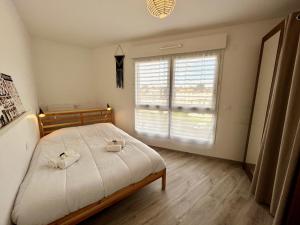 - une chambre avec un lit et 2 serviettes dans l'établissement T4 avec grande terrasse et parking privé, à Caen