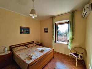 a bedroom with a bed and a window at Casa Spezzara (tra Tropea e Capo Vaticano) in Santa Domenica