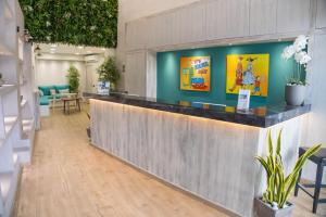 a lobby with a reception counter with plants at Connect Studios & Apartments in Athens