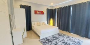 a bedroom with a bed with blue curtains and a rug at Patrick villa phuket in Bang Tao Beach