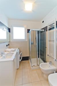 ein Bad mit einer Dusche, einem Waschbecken und einem WC in der Unterkunft Villa Marina Apartments - Agenzia Cocal in Caorle