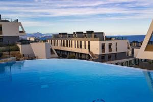 een groot zwembad voor sommige gebouwen bij Iconic Sea Views Luxury Apartment in Puerto Marino