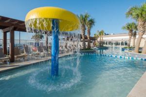 a pool with a fountain in the middle at Gaido's Seaside Inn in Galveston