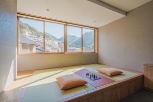 Zimmer mit einem Bett mit zwei Kissen und einem Fenster in der Unterkunft HOTEL ALGO in Kōbe