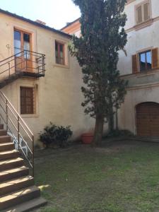 un edificio con escaleras y un árbol delante de él en CASALE LA BANDITA, en La Bandita