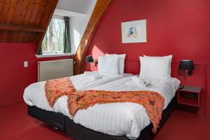 a red bedroom with a large bed with a red wall at Buitenplaats Iepenoord in Oostkapelle