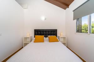 サオラにあるApartamento Jibazahora Tauroの白いベッドルーム(黄色い枕2つ付きのベッド1台付)