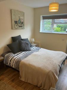 um quarto com uma cama grande e uma janela em The Garage em Wimborne Minster