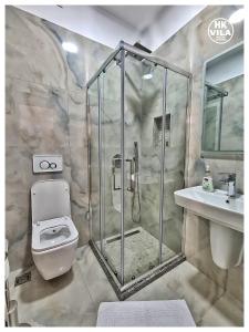 e bagno con doccia, servizi igienici e lavandino. di Vila HK a Krujë (Kruja)