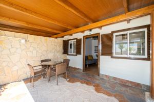 a patio with a table and chairs and a stone wall at Apartamento Jibazahora Tauro in Zahora