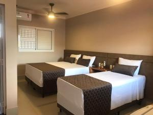 ein Schlafzimmer mit zwei Betten und einem Deckenventilator in der Unterkunft POUSADA MALA E CUIA in Rifaina