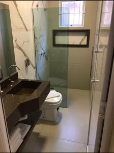 La salle de bains est pourvue d'un lavabo, de toilettes et d'une douche. dans l'établissement POUSADA MALA E CUIA, à Rifaina