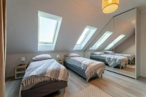Un dormitorio con dos camas y un espejo. en Porto di Mare Ustka- apartament w centrum, en Ustka