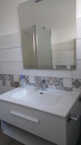 a bathroom with a white sink and a mirror at Casa Gaia in Cala Gonone