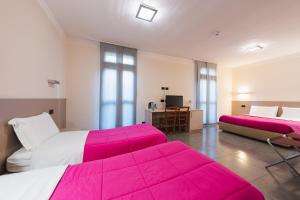 2 camas en una habitación con sábanas rosas en Parini Hotel, en Bosisio Parini