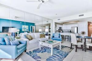 uma sala de estar com um sofá branco e cadeiras azuis em Majestic Sun 202B em Destin