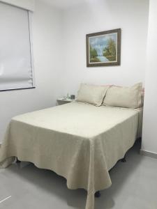 Un dormitorio blanco con una cama con una manta. en TERRAÇO EM COPACABANA VC, en Río de Janeiro