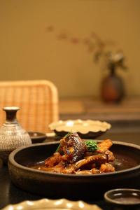 a black plate of food on a table at Yoyokaku in Karatsu