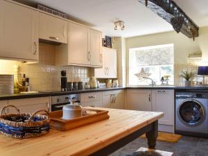 a kitchen with a wooden table and a washing machine at Meadow View Cottage - Uk33302 in Middleton
