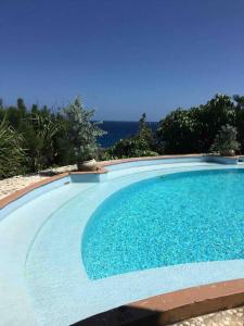 uma grande piscina azul com o oceano ao fundo em Charlie’s Place Zion Hill - close to Blue Lagoon em Port Antonio