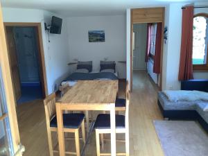 een kamer met een tafel en stoelen en een slaapkamer bij BnB Försterlodge in Schwarzsee