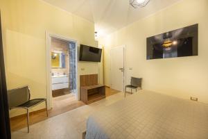 - une chambre avec un lit et une télévision murale dans l'établissement B&B Altrasia, à Catane