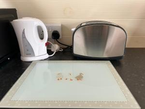 a counter top with a toaster and a plate with mice on it at Cosy Glamping Pod with shared facilities, Nr Kingsbridge and Salcombe in Kingsbridge