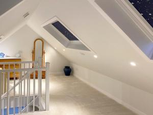 a attic bedroom with a skylight and a crib at Alma Cottage in Borgue