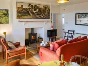 a living room with a red couch and a fireplace at Brier Dene Middle Cottage in Hartley