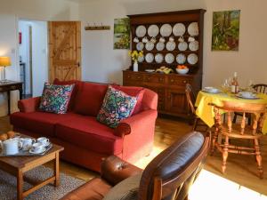 a living room with a red couch and a table at Brier Dene Middle Cottage in Hartley