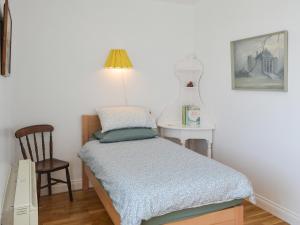 a small bedroom with a bed and a table at Brier Dene Middle Cottage in Hartley