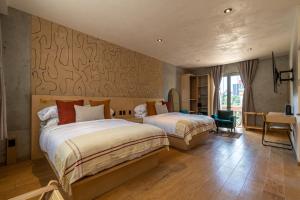 a hotel room with two beds and a desk at Boutique Hotel Durango219 in Mexico City