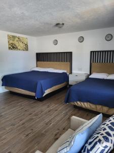 a bedroom with two beds and a couch at Budget Inn of Sebring in Sebring