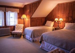 a hotel room with two beds and a chair at Franconia Inn in Franconia