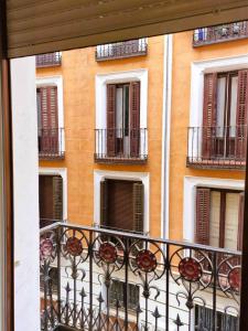 un edificio con balcones y una valla delante de él en Hostal Comercial, en Madrid