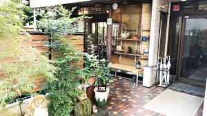 Kagetsu Ryokan في شيزوكا: غرفة مع مجموعة من النباتات الفخارية على مبنى