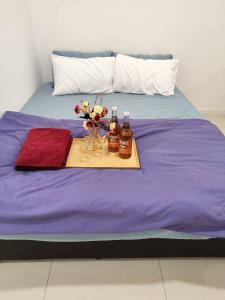 fioletowe łóżko z tacą z napojami i kwiatami w obiekcie Paradigm Mall Perfect City View 4pax w mieście Johor Bahru