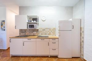 uma cozinha com armários brancos e um frigorífico branco em Apartamento Jibazahora B3 em Zahora