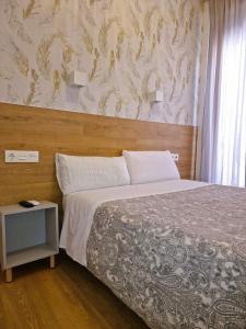 1 dormitorio con 1 cama grande y cabecero de madera en Hostal Comercial en Madrid